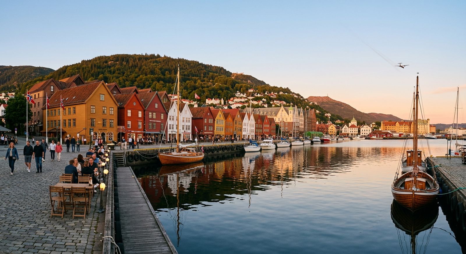 Colourful old waterfront buildings at golden hour with a plane in the sky